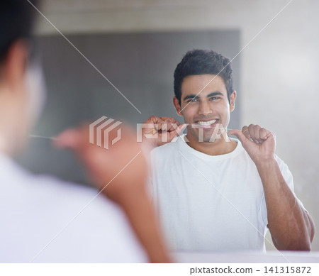Smile, mirror and man with floss in bathroom for dental hygiene, gum disease and oral care. Health, happy and person in reflection after brushing teeth for wellness, cleaning and fresh breath in home Smile, mirror and man with floss in bathroom for dental hygiene, gum disease and oral care. Health, happy and person in reflection after brushing teeth for wellness, cleaning and fresh breath in home 141315872