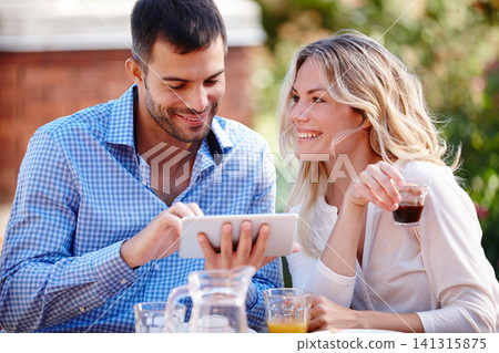 Happy couple, smiling and tablet in garden for breakfast, internet and scrolling on social media. Male person, woman and outdoors at home for mobile games, meme and drinking coffee in the morning. 141315875