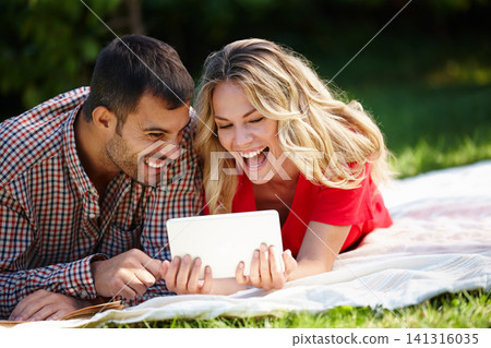 Couple, blanket and tablet to relax on grass, internet and commitment to relationship in outdoor nature. Happy people, bonding and streaming for marriage, romance and online on vacation or holiday Couple, blanket and tablet to relax on grass, internet and commitment to relationship in outdoor nature. Happy people, bonding and streaming for marriage, romance and online on vacation or holiday 141316035