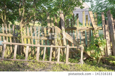 Old crumbling wooden fence in the countryside. Old crumbling wooden fence in the countryside. 141316181