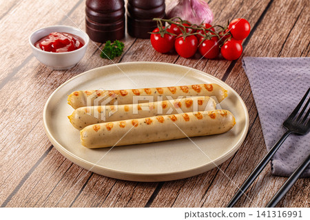 Grilled sausages on plate with cherry tomatoes and ketchup on wooden table Grilled sausages on plate with cherry tomatoes and ketchup on wooden table 141316991
