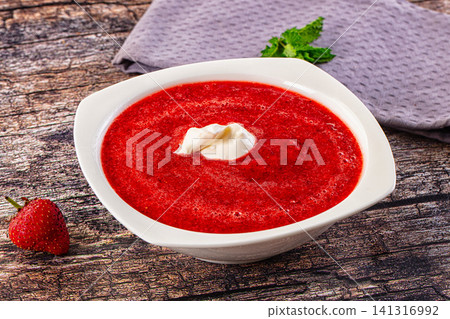 Strawberry gazpacho in white bowl with cream and mint on rustic wood Strawberry gazpacho in white bowl with cream and mint on rustic wood 141316992