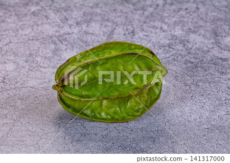 Green star fruit on textured gray surface Green star fruit on textured gray surface 141317000