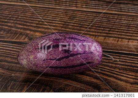 Purple striped fruit on rustic wooden surface Purple striped fruit on rustic wooden surface 141317001