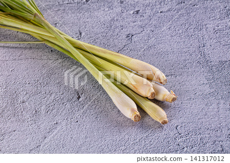 Fresh lemongrass stalks on textured gray surface Fresh lemongrass stalks on textured gray surface 141317012