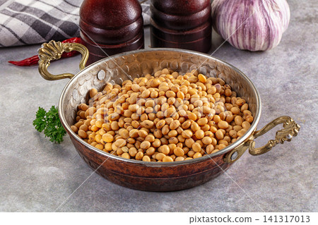 Soybeans in ornate metal bowl with garlic and spice grinders Soybeans in ornate metal bowl with garlic and spice grinders 141317013