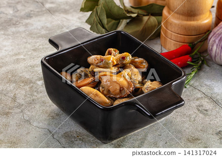 Mussels in black ceramic bowl with herbs and spices on stone surface Mussels in black ceramic bowl with herbs and spices on stone surface 141317024