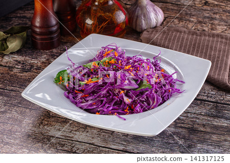 Vibrant purple cabbage salad with carrot and herbs on white plate Vibrant purple cabbage salad with carrot and herbs on white plate 141317125