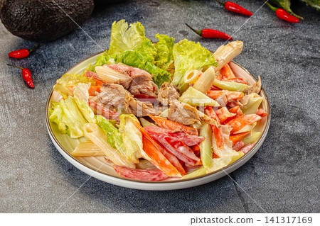 Pasta salad with shredded meat lettuce and red peppers on plate Pasta salad with shredded meat lettuce and red peppers on plate 141317169