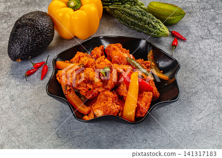 Spicy chicken curry with bell peppers and avocado on gray background Spicy chicken curry with bell peppers and avocado on gray background 141317183