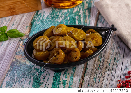 Sliced pickled jalapeno peppers in black bowl on rustic wooden table Sliced pickled jalapeno peppers in black bowl on rustic wooden table 141317250
