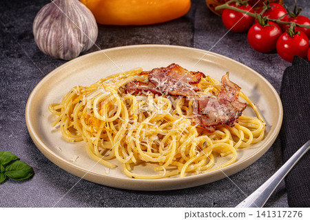 Spaghetti carbonara with crispy bacon and grated cheese on rustic plate Spaghetti carbonara with crispy bacon and grated cheese on rustic plate 141317276