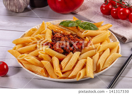Penne pasta with meat sauce and basil on white plate Penne pasta with meat sauce and basil on white plate 141317330