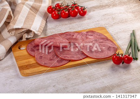 Sliced deli meat on wooden cutting board with cherry tomatoes and green onions Sliced deli meat on wooden cutting board with cherry tomatoes and green onions 141317347
