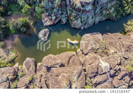 Aerial view of the natural rock pool, elevated viewing platform and striking granite rock formations at Cranky Rock Nature Reserve near Warialda, NSW. Carved by Reedy Creek 141318347