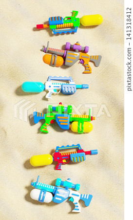 Colorful plastic water guns collection flat lay on sea beach sand, summer vacation background, 3D render Colorful plastic water guns collection flat lay on sea beach sand, summer vacation background, 3D render 141318412