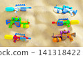 Colorful Water Guns on Sandy Beach Background with Copy Space Summer Vacation Banner Template 141318422