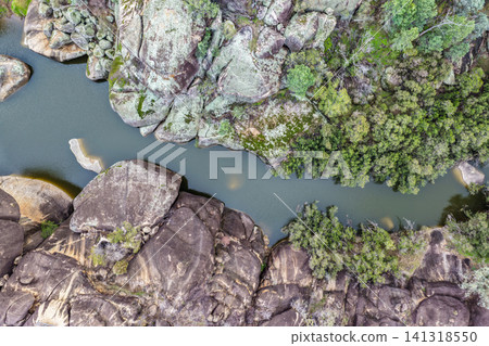 Aerial view of the natural rock pool and striking granite rock formations at Cranky Rock Nature Reserve near Warialda, NSW. Carved by Reedy Creek and surrounded by native bushland Aerial view of the natural rock pool and striking granite rock formations at Cranky Rock Nature Reserve near Warialda, NSW. Carved by Reedy Creek and surrounded by native bushland 141318550