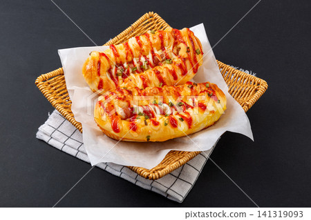 fresh baked sausage bread with cheese and ketchup drizzle 141319093