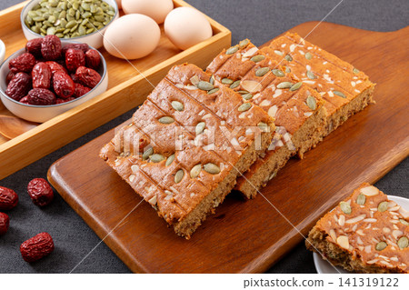 sliced jujube brown sugar cake topped with mixed nuts and seeds 141319122