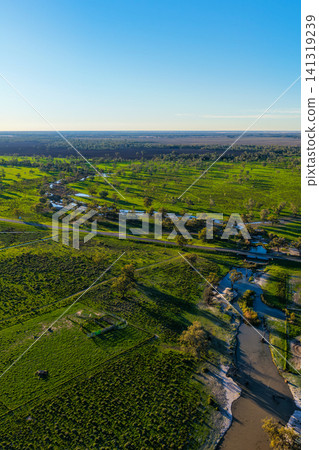 Aerial vertical view of a winding creek flowing through the lush green landscape of Pilliga, showcasing vibrant bushland, rich natural textures and the peaceful rural scenery near Pilliga, NSW Aerial vertical view of a winding creek flowing through the lush green landscape of Pilliga, showcasing vibrant bushland, rich natural textures and the peaceful rural scenery near Pilliga, NSW 141319239