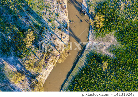 Aerial downward view of a creek winding through the lush green landscape surrounding the Pilliga Artesian Bore Baths, highlighting the natural beauty and peaceful bushland setting near Pilliga, NSW, Aerial downward view of a creek winding through the lush green landscape surrounding the Pilliga Artesian Bore Baths, highlighting the natural beauty and peaceful bushland setting near Pilliga, NSW, 141319242
