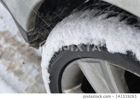 Snow Covered Winter Tire on Car Wheel with Sidewall Text, Seasonal Automotive Cold Weather Safety Detail Snow Covered Winter Tire on Car Wheel with Sidewall Text, Seasonal Automotive Cold Weather Safety Detail 141319263
