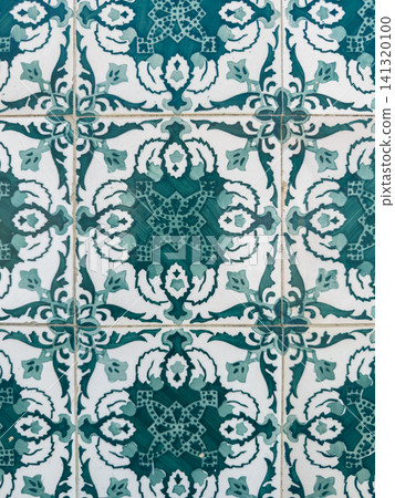 Close up of intricate green and white Portuguese azulejo tiles featuring a repeating floral and geometric pattern on a ceramic wall for classic architecture Close up of intricate green and white Portuguese azulejo tiles featuring a repeating floral and geometric pattern on a ceramic wall for classic architecture 141320100