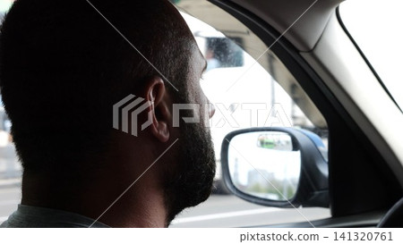 Confident bearded man looking concentrated to urban road while riding electric automobile. Guy driving the auto at highway. Serious male driver operating a motor car at town. Slow motion Confident bearded man looking concentrated to urban road while riding electric automobile. Guy driving the auto at highway. Serious male driver operating a motor car at town. Slow motion 141320761