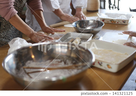A woman making gyoza wrappers by hand A woman making gyoza wrappers by hand 141321125