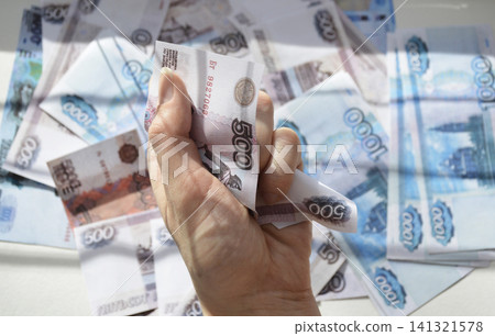 A woman's hand holds a crumpled Russian ruble banknote A woman's hand holds a crumpled Russian ruble banknote 141321578