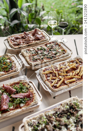 many different Pinsa types on garden restaurant pizza slice buffet table outdoors many different Pinsa types on garden restaurant pizza slice buffet table outdoors 141321890