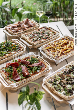 many different Pinsa types on garden restaurant pizza slice buffet table outdoors many different Pinsa types on garden restaurant pizza slice buffet table outdoors 141321891