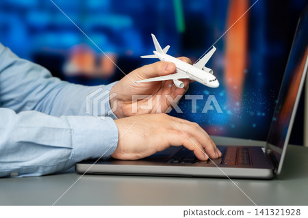 Airplane and businessman using a laptop. Concept of business travel, searching for airline tickets, online flight booking, trip planning and internet 141321928