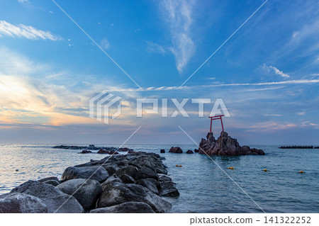夕陽西下，海面上聳立著岩石和鳥居。 141322252