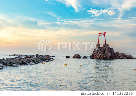 夕陽西下，海面上聳立著岩石和鳥居。 141322256
