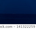 地平線上排列著一排魷魚捕撈船的燈光，吸引魚群。 141322259