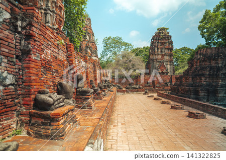 Ancient headless Buddha statues lining the red brick wall at Wat Mahathat in Ayutthaya, Thailand. 141322825