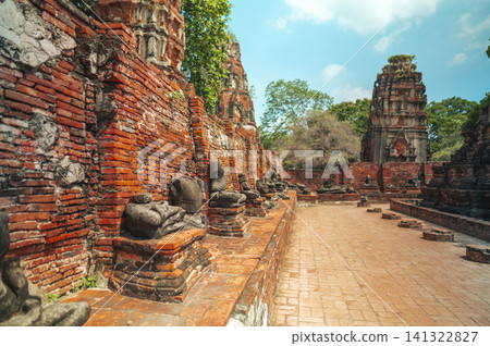 Ancient headless Buddha statues lining the red brick wall at Wat Mahathat in Ayutthaya, Thailand. Ancient headless Buddha statues lining the red brick wall at Wat Mahathat in Ayutthaya, Thailand. 141322827