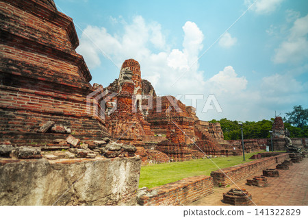 Ancient headless Buddha statues lining the red brick wall at Wat Mahathat in Ayutthaya, Thailand. 141322829