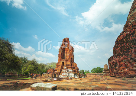 Ancient headless Buddha statues lining the red brick wall at Wat Mahathat in Ayutthaya, Thailand. 141322834