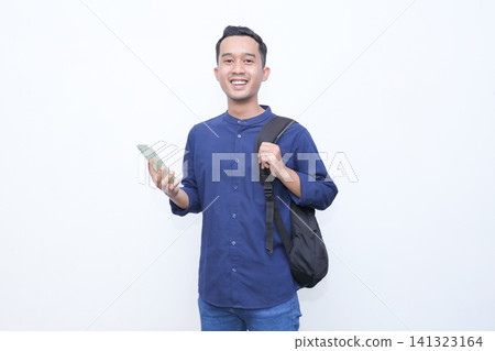 Man stares at phone with puzzled expression. He wears blue shirt and carries backpack. He holds phone while looking at screen. Background is plain white. Image conveys confusion or curiosity Man stares at phone with puzzled expression. He wears blue shirt and carries backpack. He holds phone while looking at screen. Background is plain white. Image conveys confusion or curiosity 141323164