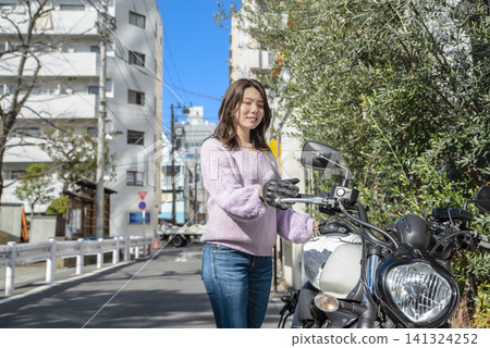 A female rider and her Vulcan S preparing for a touring trip. A female rider and her Vulcan S preparing for a touring trip. 141324252