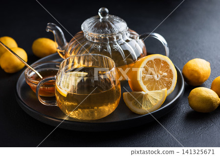 Hot lemon tea with honey in glass pot and mug Hot lemon tea with honey in glass pot and mug 141325671