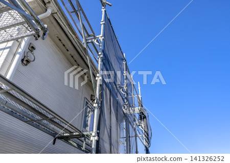 A house and temporary scaffolding immediately after the start of renovations; a copy space under the blue sky. 141326252