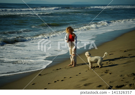 Teen Girl Training Lagotto to Fetch on Beach Teen Girl Training Lagotto to Fetch on Beach 141326357
