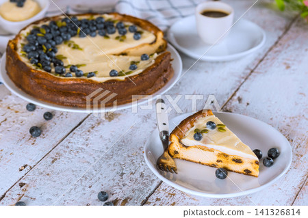 Bakery display cheesecake with blueberries cup of coffee on wooden table Bakery display cheesecake with blueberries cup of coffee on wooden table 141326814