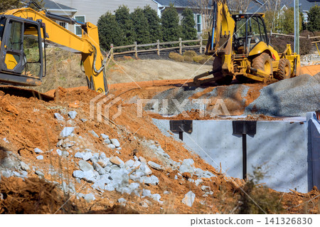 Construction site with heavy machinery working on project in suburban area Construction site with heavy machinery working on project in suburban area 141326830