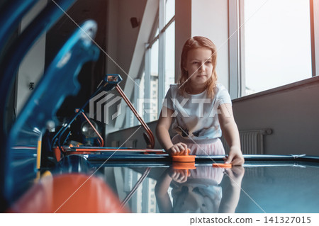 beautiful brunette female playing air hockey with friend beautiful brunette female playing air hockey with friend 141327015