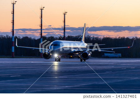 Modern passenger aircraft taxiing at the airport early in the morning Modern passenger aircraft taxiing at the airport early in the morning 141327401
